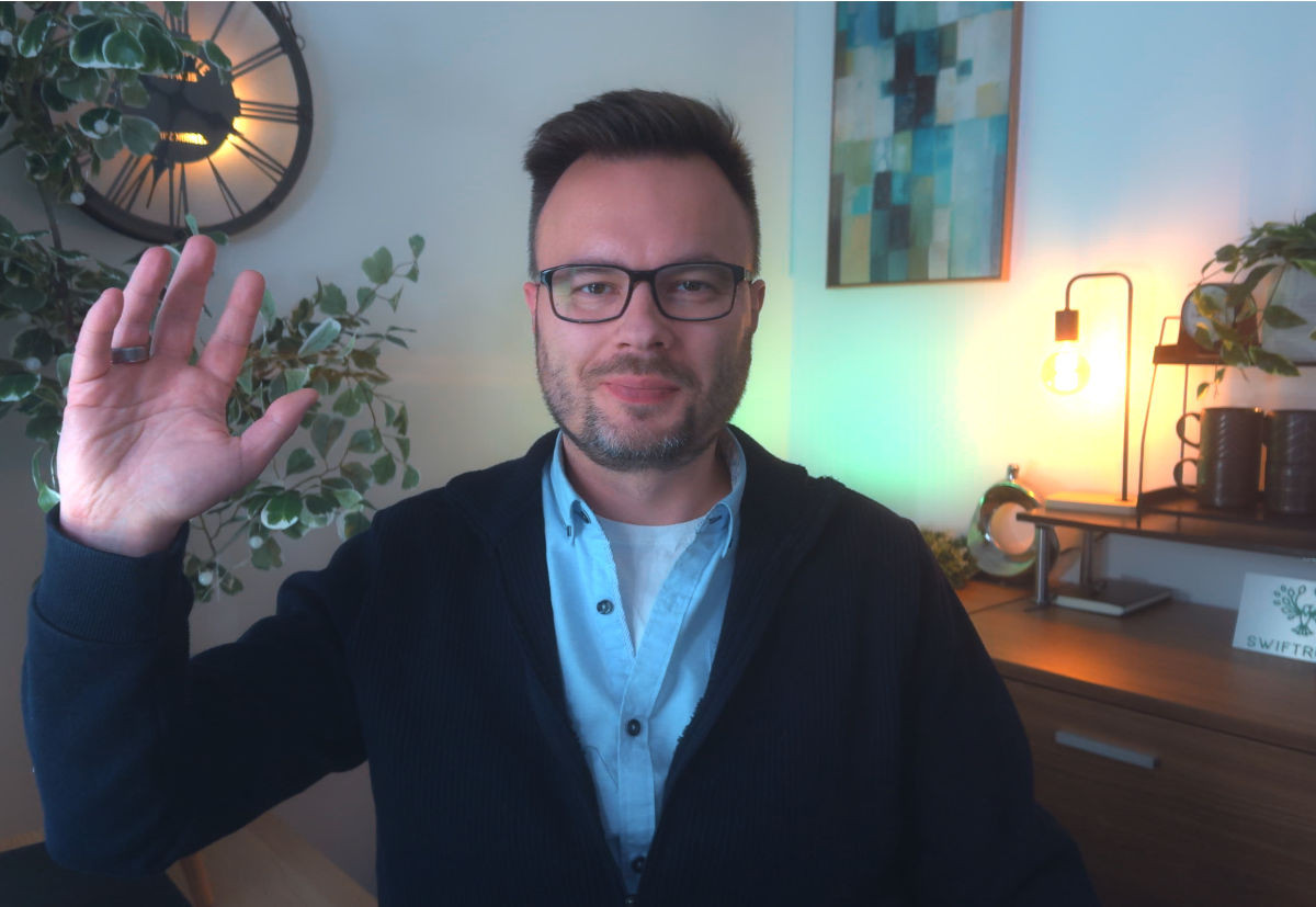 Alek Mlynek waving from his office.